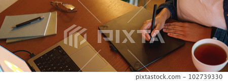 Cropped image of a graphic designer using digital tablet in his work at home office 102739330