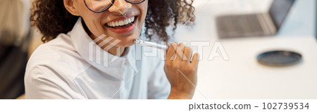 Smiling african businesswoman making notes while drinking tea during break in cafe Smiling african businesswoman making notes while drinking tea during break in cafe 102739534
