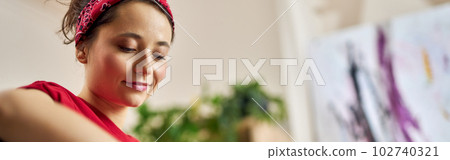 Creative young woman playing acoustic guitar while spending time at home alone 102740321