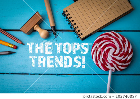 The Tops Trends. Text and office supplies on blue wooden background The Tops Trends. Text and office supplies on blue wooden background 102740857