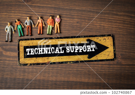Technical Support. Direction arrow and miniature human figures on a wooden background Technical Support. Direction arrow and miniature human figures on a wooden background 102740867