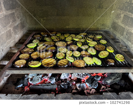 Pieces of fresh zucchini and eggplant are grilled in a charcoal oven 102741298