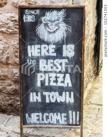 Colorful signboard of a pizzeria drawn in chalk on a slate board  102741303