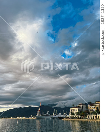 Marina with luxury yachts near the coast with expensive villas against the backdrop of mountains Marina with luxury yachts near the coast with expensive villas against the backdrop of mountains 102741330
