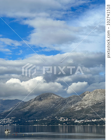 Thunderclouds over the mountains near the sea coast Thunderclouds over the mountains near the sea coast 102741518