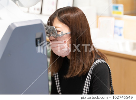Woman having an eye exam at an optician Woman having an eye exam at an optician 102745549