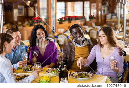 Couple on friendly meeting over dinner with wine in restaurant 102748046