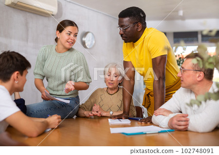 Interested girl student discussing with group of coursemates 102748091