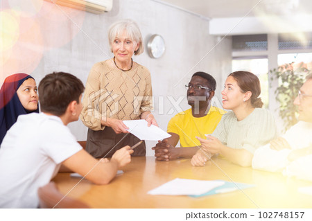 Elderly female tutor conducting foreign language speaking club Elderly female tutor conducting foreign language speaking club 102748157