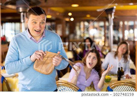 Thief pulls out a handbag from a woman during dinner in restaurant Thief pulls out a handbag from a woman during dinner in restaurant 102748159