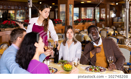 Couple on friendly meeting over dinner with wine in restaurant Couple on friendly meeting over dinner with wine in restaurant 102748208