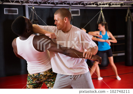 Men and women exercising during self-protection training Men and women exercising during self-protection training 102748211