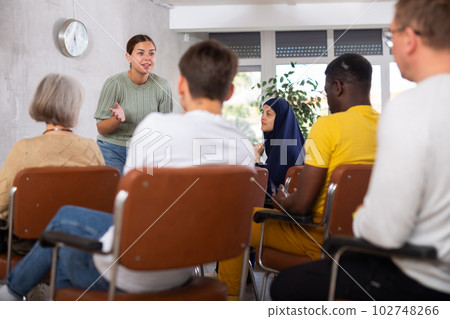 Young positive woman giving lecture in office Young positive woman giving lecture in office 102748266