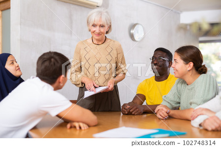 Elderly manager holds round table meetings for employees of different nationalities Elderly manager holds round table meetings for employees of different nationalities 102748314
