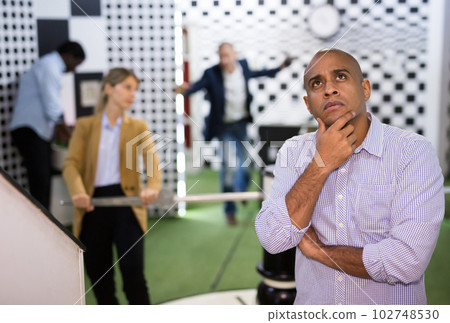 Portrait of bewildered man spending time with colleagues in quest room Portrait of bewildered man spending time with colleagues in quest room 102748530