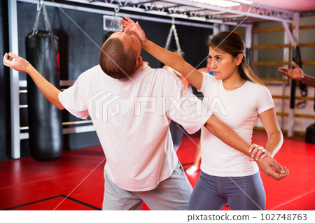 Man and woman practicing self-protection moves in gym Man and woman practicing self-protection moves in gym 102748763