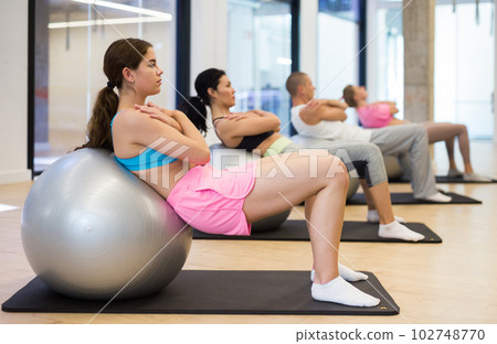 Young woman training pilates at group class 102748770