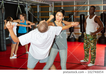 Man and women exercising during self-defense training 102748854