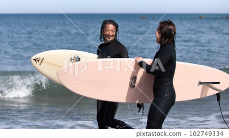 Men and women surfing on a sunny day 102749334
