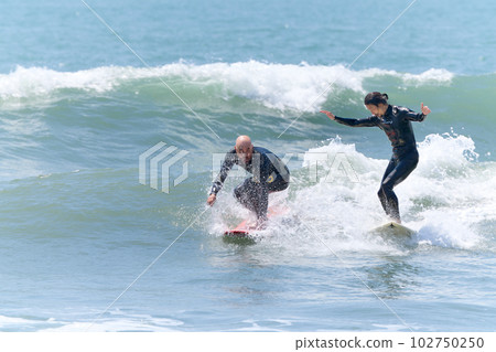 Two men enjoying surfing Two men enjoying surfing 102750250