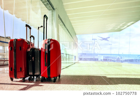 stack of traveling luggage in airport terminal building with passenger plane flying background 102750778