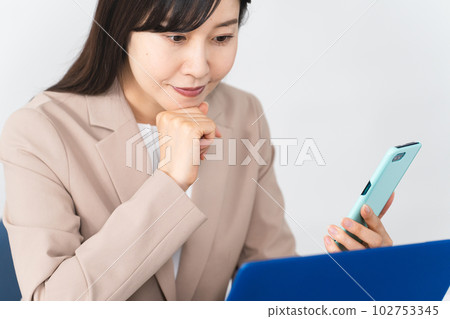 Young woman using laptop and smartphone Business image Young woman using laptop and smartphone Business image 102753345