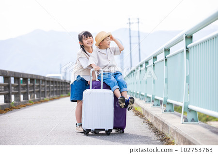 帶著手提箱旅行的一個微笑的孩子 帶著手提箱旅行的一個微笑的孩子 102753763