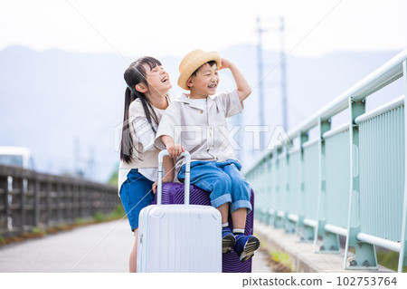 帶著手提箱旅行的一個微笑的孩子 帶著手提箱旅行的一個微笑的孩子 102753764