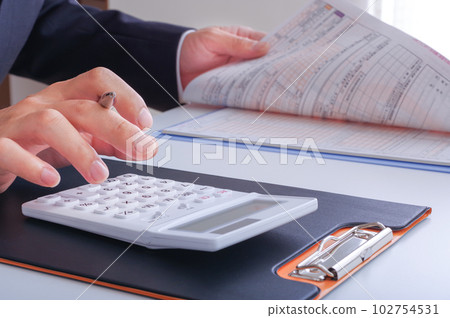 在一個用計算器計算金錢的人手中 102754531
