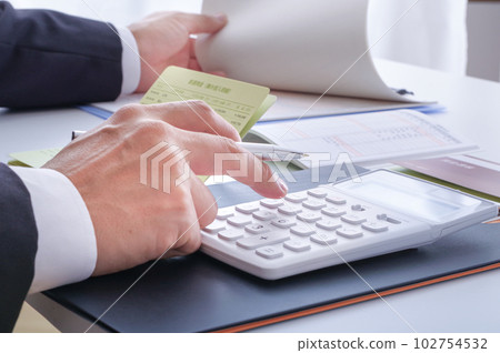 在一個用計算器計算金錢的人手中 102754532