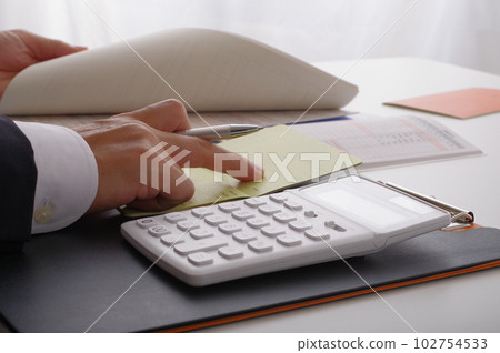 在一個用計算器計算金錢的人手中 102754533
