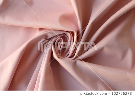 Swirled pink satin fabric with elegant folds as background 102756278