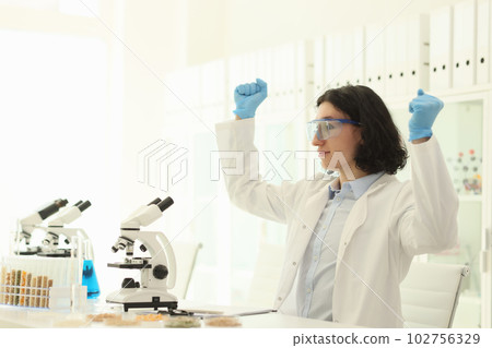 Joyful male scientist in protective goggles raises hands Joyful male scientist in protective goggles raises hands 102756329