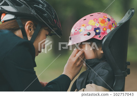 Wearing a bicycle helmet for both mother and child Wearing a bicycle helmet for both mother and child 102757043