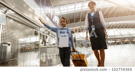 Female airport worker helps a little boy to find correct gate for boarding at the airport 102759369