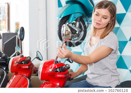 Smiling female is looking on new motobikes Smiling female is looking on new motobikes 102760128