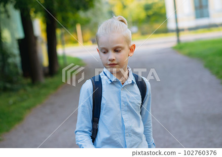caucasian boy walking from school wearing school bag. Begining of academic year caucasian boy walking from school wearing school bag. Begining of academic year 102760376