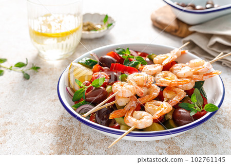 Shrimp kebab roasted on skewers and fresh vegetable salad Shrimp kebab roasted on skewers and fresh vegetable salad 102761145