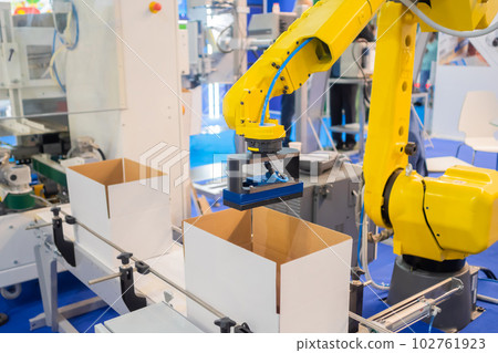 Yellow robotic arm manipulator working with cardboard boxes - sorting system 102761923