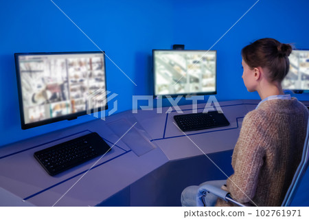 Woman security guard looking at modern cctv camera monitors Woman security guard looking at modern cctv camera monitors 102761971