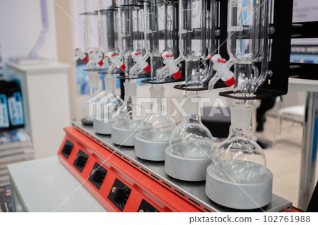 Laboratory equipment - empty glass vials on heating mantle in row Laboratory equipment - empty glass vials on heating mantle in row 102761988
