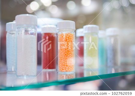 Plastic recycling - secondary granules in glass vessels - close up 102762059