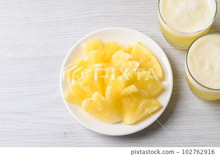 Sliced pineapple fruit with pineapple smoothie in glass, top view 102762916