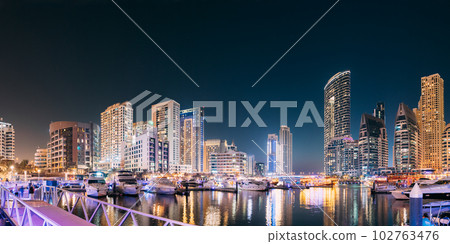 Beautiful Night View Of Dubai Marina Towers. Yachts Moored Near City Pier, Jetty In Evening Night Illuminations. Panorama, Panoramic View 102763476