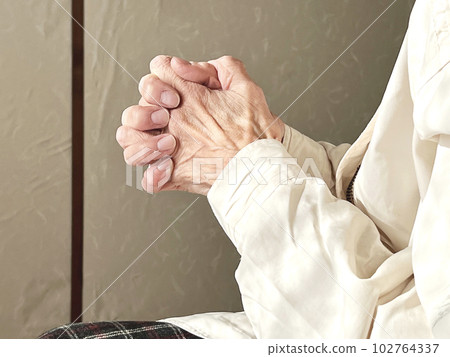 Elderly woman praying with her fingers crossed Elderly woman praying with her fingers crossed 102764337