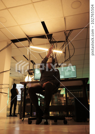 Anonymous hacker coding malware in augmented reality, making hand gesture, attacking database server, cybercrime. Computer system hacking simulation, information phishing 102765504