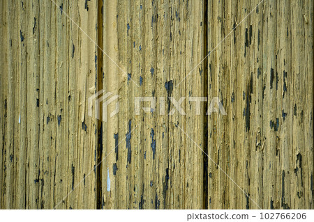 Old cracked yellow paint on boards 102766206