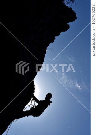 Silhouette of a rock climber hanging on the wall Silhouette of a rock climber hanging on the wall 102766228