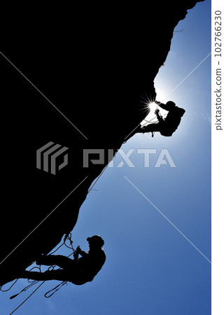 Silhouette of a rock climber hanging on the wall Silhouette of a rock climber hanging on the wall 102766230