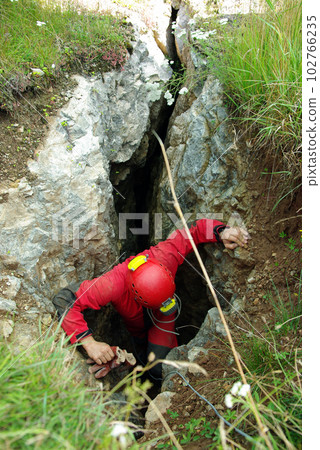 Caver descends in a cave Caver descends in a cave 102766235